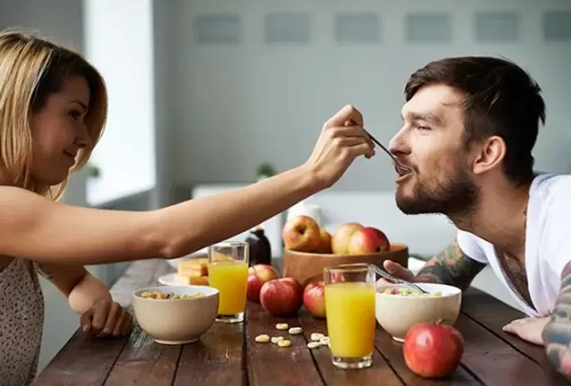 en kvinde fodrer en mand med nødder for at øge styrken